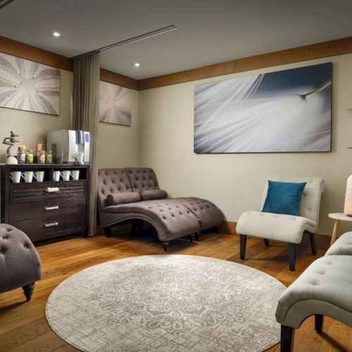 A cozy bedroom with two double beds, warm wood accents, a flat screen, plants, and soft lighting for a comfortable retreat.